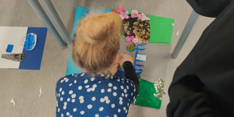 Pige laver noget kreativt på gulvet