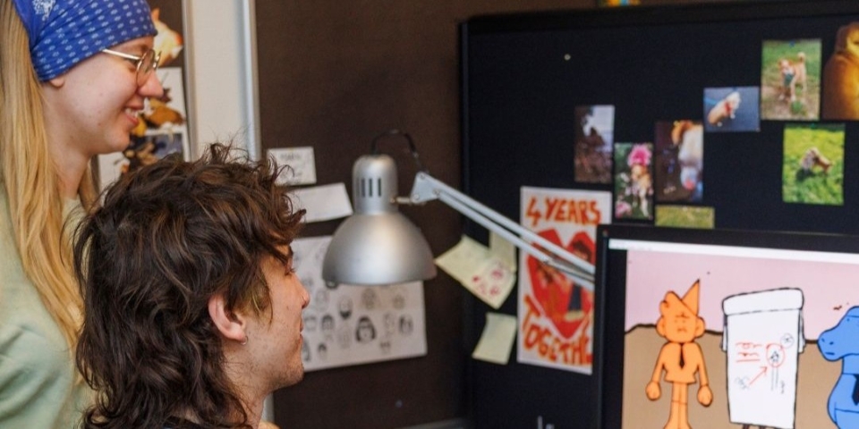 Two people looking at an animation film